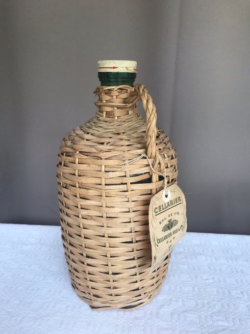 Dame Jeanne vintage, bouteille avec osier de l'eau de vie Cellarier