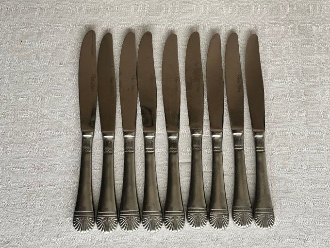 Lot de 9 couteaux en inox, Modèle coquille, art déco, signé Roger Orfèvre.